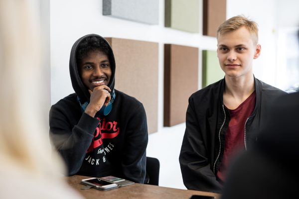 Två elever på Praktiska Gymnasiet sitter vid ett bord.