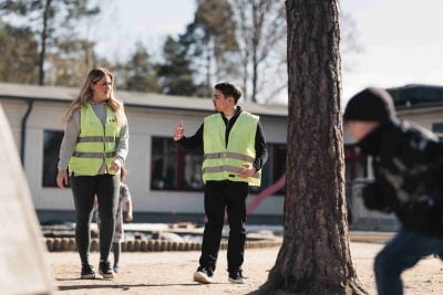 Två elever i reflexvästar på praktik på en förskola
