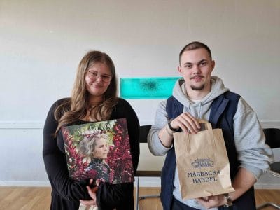 Två elever, varav en håller i "En sång till Selma” som lp-skiva och en annan i en brun papperspåse från Mårbacka.