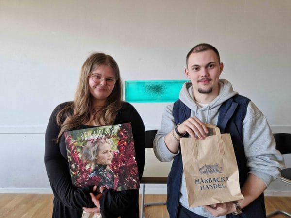 Två elever, varav en håller i "En sång till Selma” som lp-skiva och en annan i en brun papperspåse från Mårbacka.