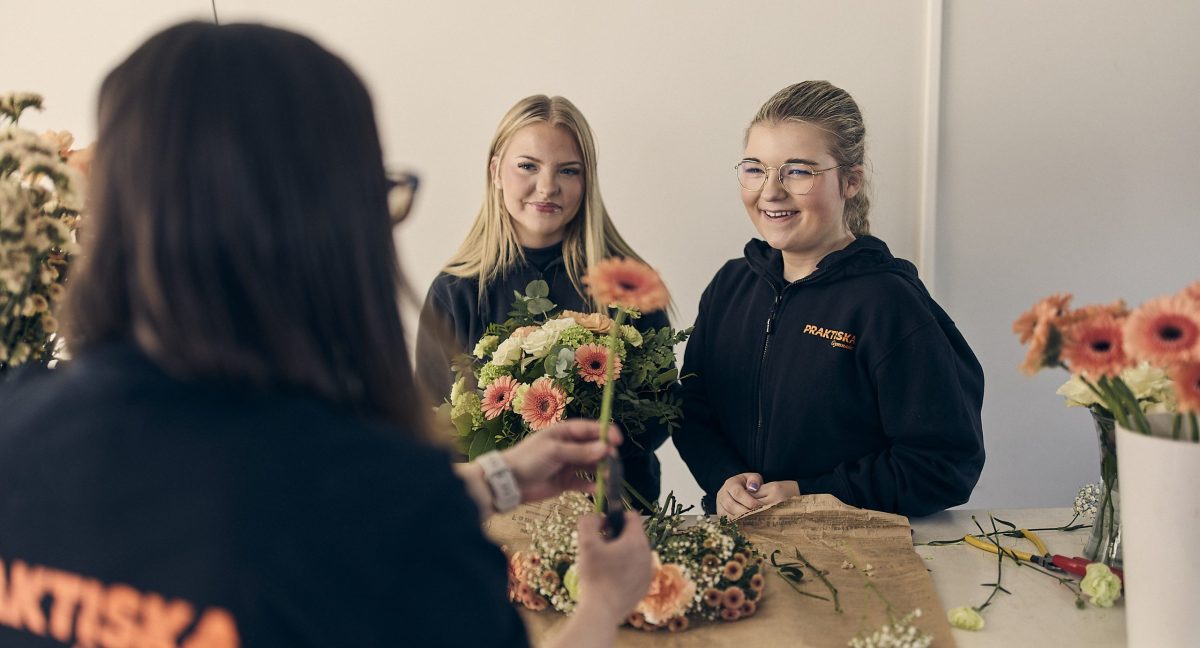 Två elever på floristprogrammet som lär sig binda en bukett