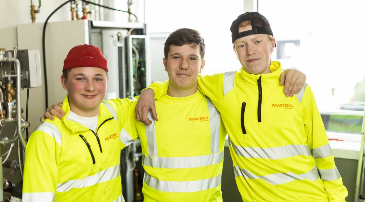 Tre elever som står på rad och håller varandra om axlarna.