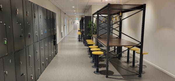 Skolkorridor med skåp och sittplatser.
