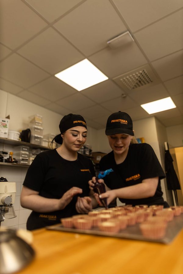 Två elever på Praktiska Gymnasiet i Södertälje som bakar hallongrottor.