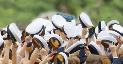 Studentmössor som viftas i luften.