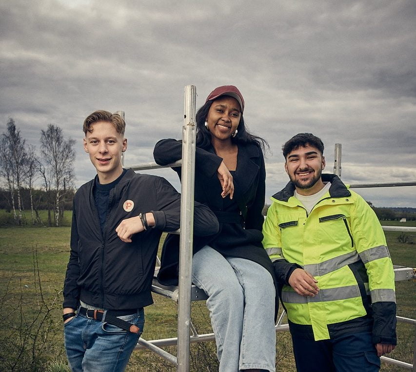 Tre elever vid en byggställning.