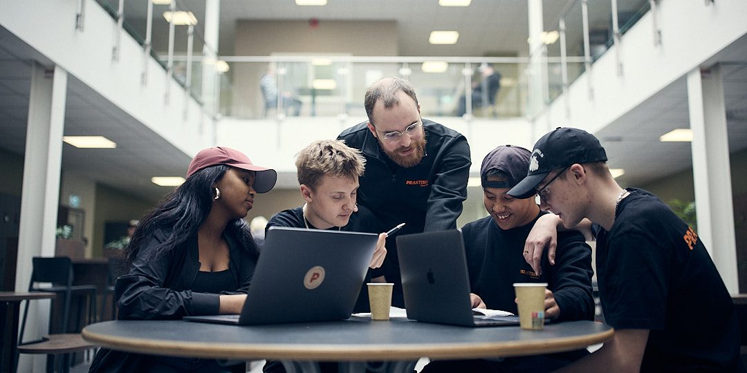 Fyra elever som pluggar i skolan och får hjälp av en lärare.