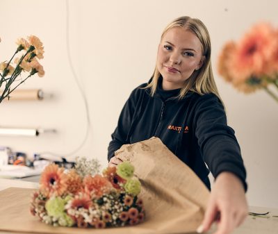 Elev som slår in en blombukett i papper.