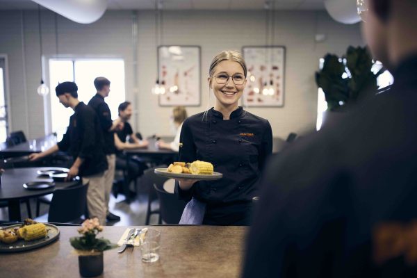 Elev som serverar mat.