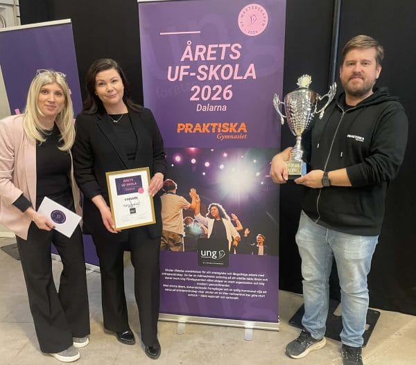 Tre lärare varav en håller i en pokal. Vinnare av årets UF-Skola 2026.